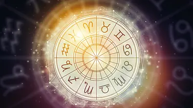 Vor einem dunklen Hintergrund erstrahlt der astrologische Tierkreis in goldenem Licht.  - Foto: Alexey Surgay/iStock