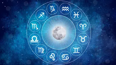 Das Bild zeigt einen leuchtenden Vollmond in der Mitte eines astrologischen Tierkreises mit den zwölf Sternzeichen vor einem blau schimmernden Sternenhimmel. - Foto: sudarat bunloet/iStock