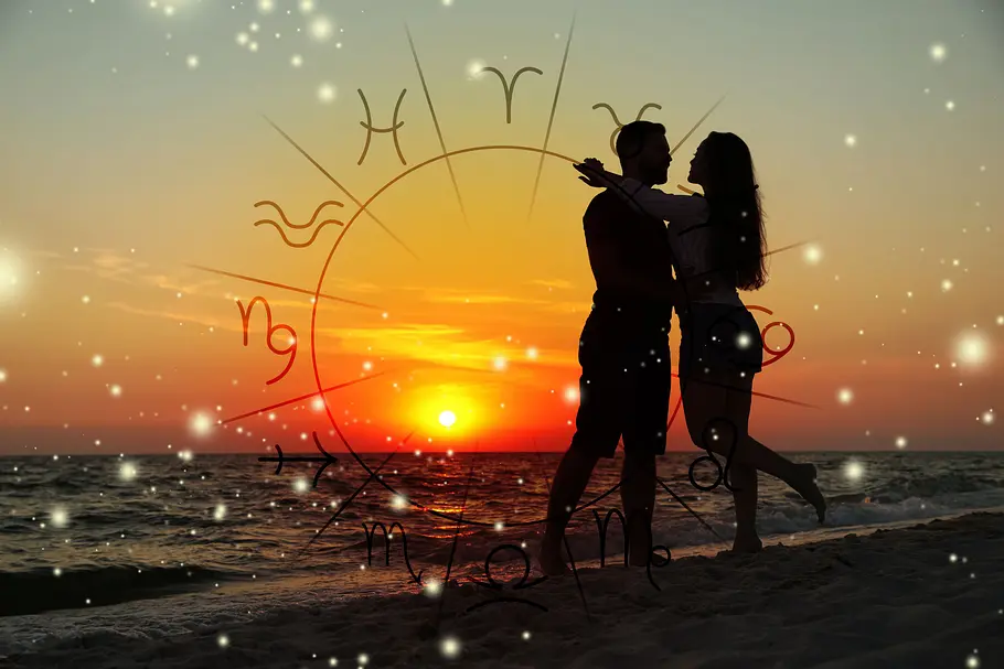 Ein verliebtes Paar steht am Strand im Sonnenuntergang. Davor ist ein Sternzeichen-Kreis zu sehen.