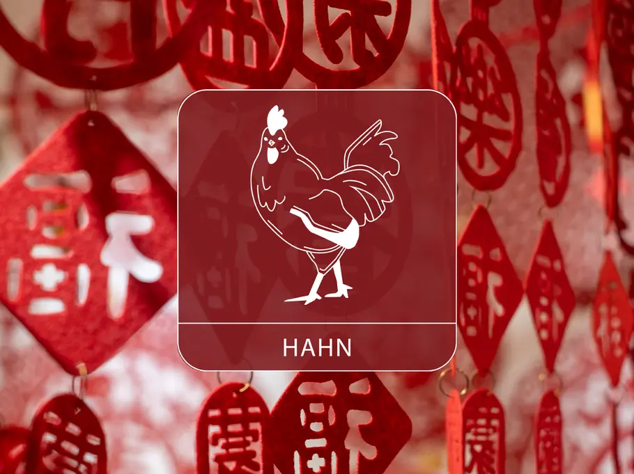 Das Sternzeichen Hahn vor einem roten, dekorativen Vorhang aus chinesischen Symbolen