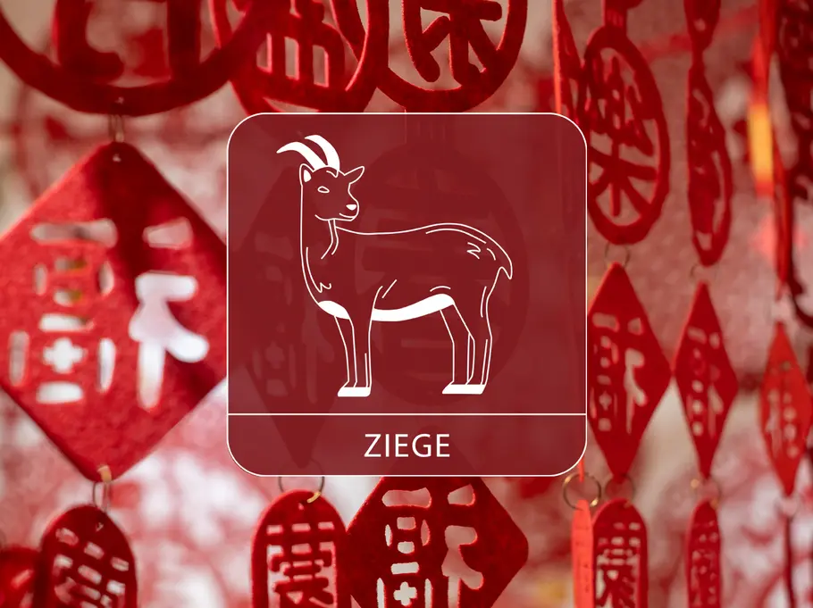Das Sternzeichen Ziege vor einem roten, dekorativen Vorhang aus chinesischen Symbolen
