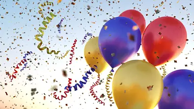 Bunte Luftballons steigen neben Konfetti und Luftschlangen in den Himmel - Foto: matejmo/iStock Bunte Luftballons steigen neben Konfetti und Luftschlangen in den Himmel - Foto: matejmo/iStock