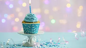 Kleiner Muffin vor einem glitzernden Hintergrund - Foto: Africa Studio / AdobeStock