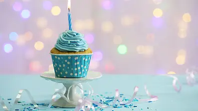 Kleiner Muffin vor einem glitzernden Hintergrund - Foto: Africa Studio / AdobeStock