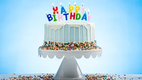 Geburtstagstorte mit Kerzen die Happy Birthday schreiben - Foto: ToddKuhns / AdobeStock