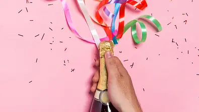 Bunte Luftschlangen die aus einer Sektflasche kommen - Foto: iStock/Makidotvn Bunte Luftschlangen die aus einer Sektflasche kommen - Foto: iStock/Makidotvn