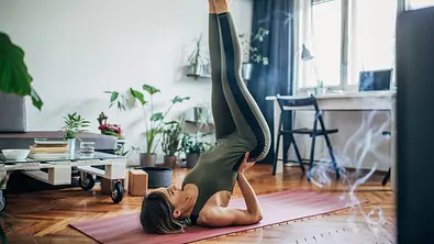 Frau macht eine Rückenübung in ihrem Wohnzimmer - Foto: South_agency / iStock Frau macht eine Rückenübung in ihrem Wohnzimmer - Foto: South_agency / iStock