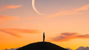 Mondsichel am Himmel und darunter eine Person auf einem Hügel - Foto: Breezze / AdobeStock Mondsichel am Himmel und darunter eine Person auf einem Hügel - Foto: Breezze / AdobeStock