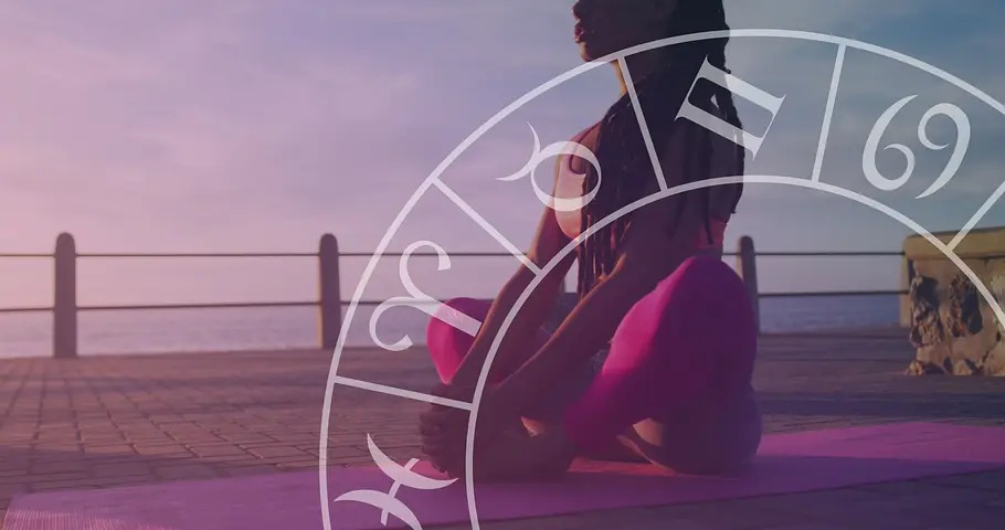 Frau sitzt auf einer Yoga-Matte. Davor ein astrologischer Kleid.