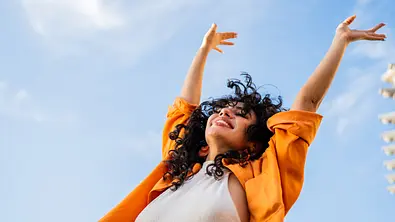 Unbeschwerte Frau genießt einen sonnigen Tag draußen  - Foto: iStock/FG Trade Latin