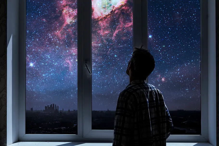 Das Merkur-Jupiter-Horoskop ab dem 21.02.2025 Mann beobachtet durch sein Fenster die Galaxie