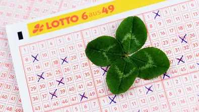 Ein Lotto-Schein auf dem ein Glückskleeblatt liegt - Foto: hsvrs / iStock