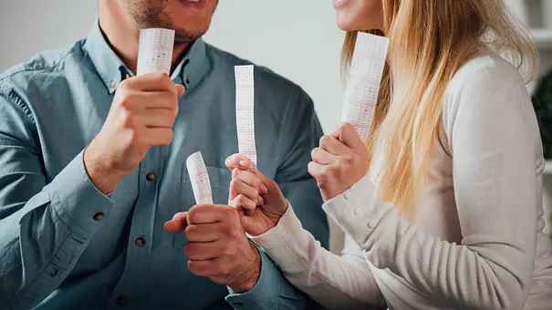 Ein Mann und eine Frau halten Lottoscheine in der Hand - Foto: LIGHTFIELD STUDIOS / AdobeStock Ein Mann und eine Frau halten Lottoscheine in der Hand - Foto: LIGHTFIELD STUDIOS / AdobeStock