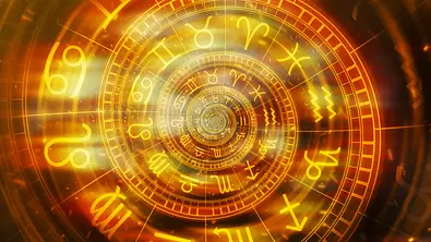 Das Bild zeigt einen leuchtend goldenen, spiralförmig angeordneten astrologischen Tierkreis mit den Symbolen der verschiedenen Sternzeichen. - Foto: BitsAndSplits/iStock
