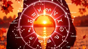 Ein Tierkreis mit Sternbildern überlagert die Silhouetten eines Paares am Wasser bei Sonnenuntergang, umrahmt von rotem Herbstlaub. - Foto:  BillionPhotos.com/AdobeStock und Astrowoche.de, KI generiert