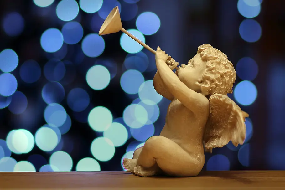 Das Engeltarot für alle 12 Sternzeichen für die Woche vom 3. bis zum 9. März 2025 Kleine Engelstatue bläst eine Trompete vor einem blauen Hintergrund