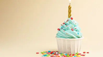 Ein Geburtstags-Cupcake mit einer goldenen Kerze - Foto: New Africa / AdobeStock