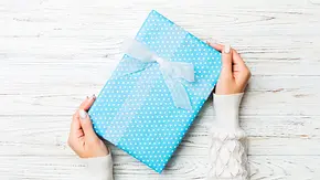 Blaues Geschenk wird übergeben - Foto: sosiukin / AdobeStock