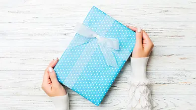 Blaues Geschenk wird übergeben - Foto: sosiukin / AdobeStock