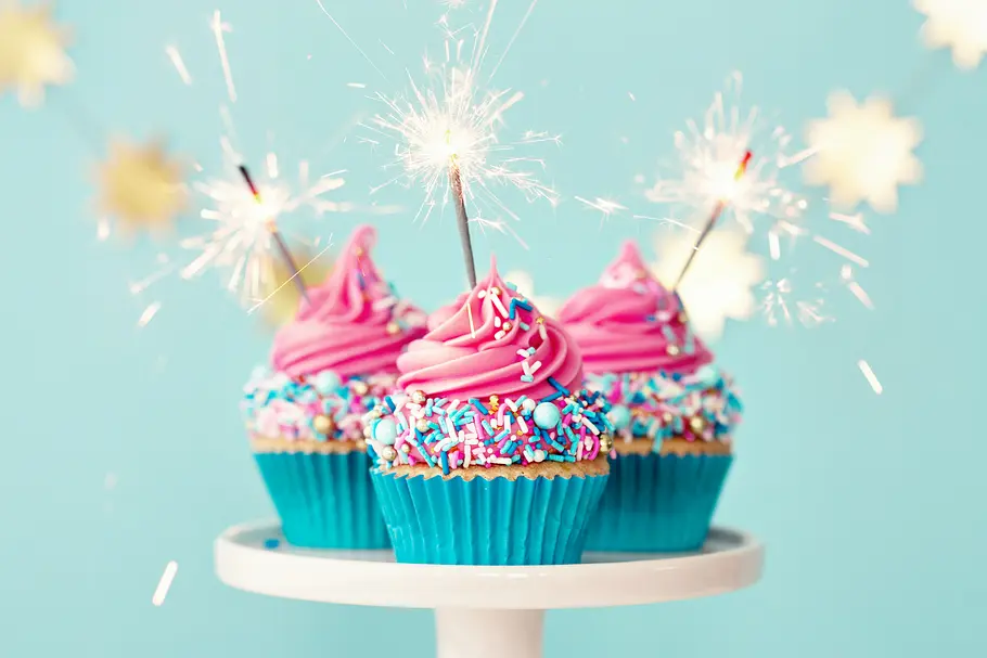 Geburtstagshoroskop für die Woche vom 10. bis zum 16. März 2025 Drei Geburtstags-Cupcakes mit Wunderkerzen und bunten Streuseln dekoriert