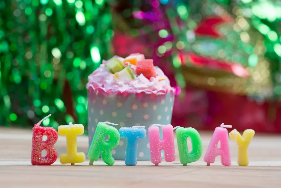 Geburtstagshoroskop für die Woche vom 3. bis zum 9. März 2025 Schriftzug Birthday in bunten Kerzen vor einem Küchlein und Party-Deko