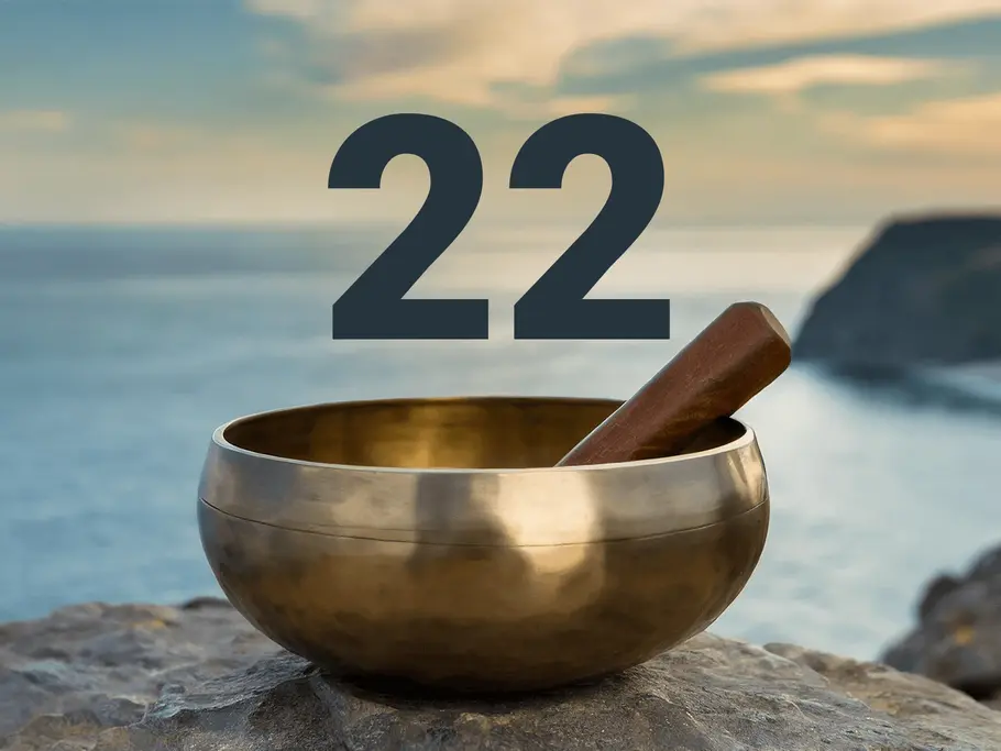 Eine Klangschale mit der Zahl 22 steht auf einem Felsvorsprung vor blauem Meer