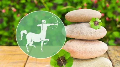 Vier glatte Steine sind mit Kleeblättern auf Holz gestapelt. Daneben steht das Schütze-Symbol in einem grünen Kreis. - Foto: Collage mit Lidiia Moor/iStock und Sonja Calovini/AdobeStock Vier glatte Steine sind mit Kleeblättern auf Holz gestapelt. Daneben steht das Schütze-Symbol in einem grünen Kreis. - Foto: Collage mit Lidiia Moor/iStock und Sonja Calovini/AdobeStock
