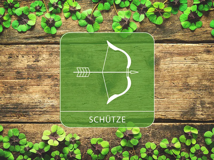 Sternzeichen Schütze vor einem Holz-Hintergrund mit Glücksklee