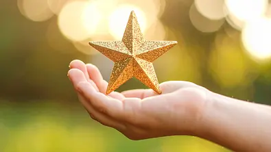 Glitzerstern steht wird in Kinderhand gehalten - Foto: AdobeFirefly (generiert mit KI)