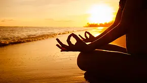 Jemand meditiert während dem Sonnenaufgang am Strand - Foto: iStock/kieferpix Jemand meditiert während dem Sonnenaufgang am Strand - Foto: iStock/kieferpix