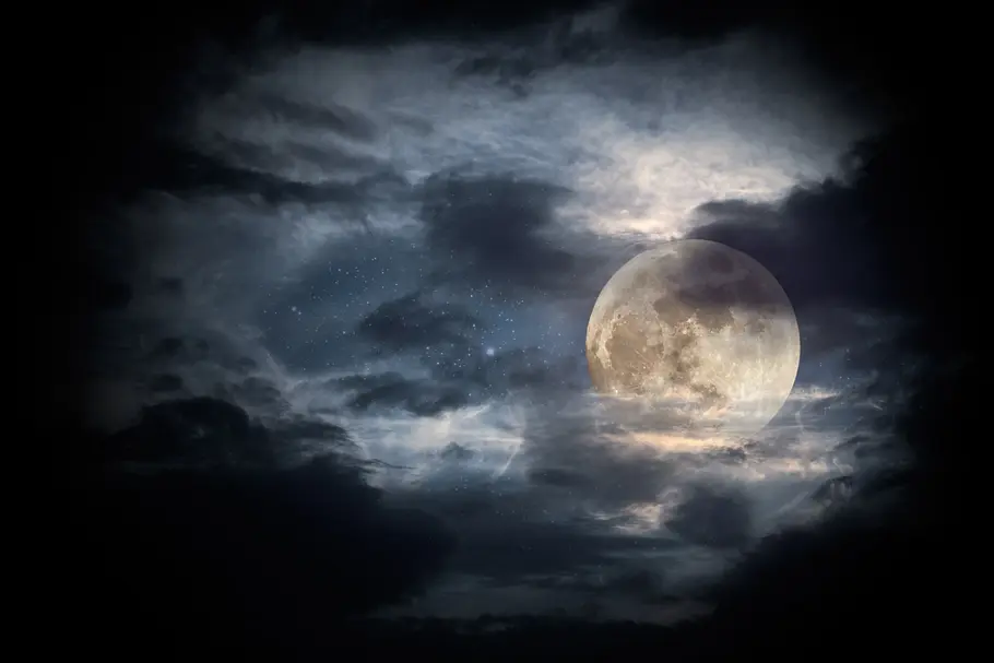 Vollmond steht umringt von Wolken am Nachthimmel