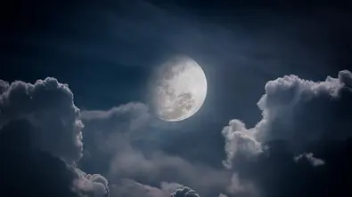 Mond am Nachthimmel zwischen Wolken - Foto: iStock/kdshutterman