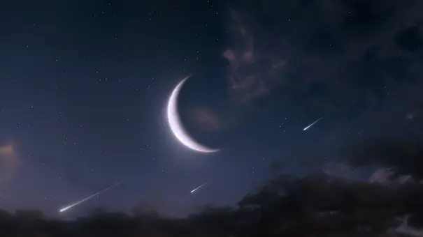 An einem Nachthimmel ist groß leuchtenden die Neumond-Sichel zu sehen. Außerdem erleuchten drei Sternschnuppen den dunkel Nachthimmel. - Foto: Nazarii Neshcherenskyi/iStock An einem Nachthimmel ist groß leuchtenden die Neumond-Sichel zu sehen. Außerdem erleuchten drei Sternschnuppen den dunkel Nachthimmel. - Foto: Nazarii Neshcherenskyi/iStock