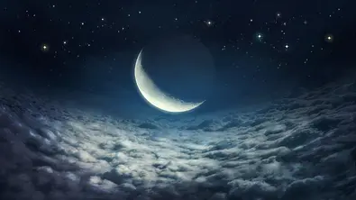 Ein leuchtender Neumond umgeben von einer Wolkendecke und leuchtenden Sternen - Foto: egal/iStock